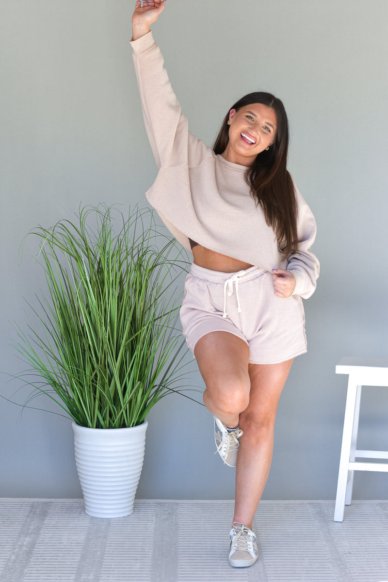 two piece tan lounge set with cropped long sleeve top and high waisted shorts